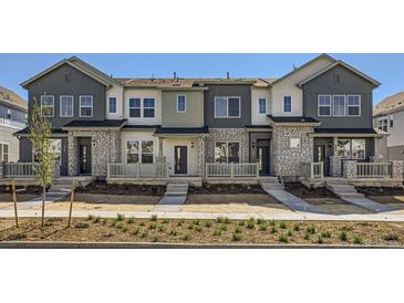 Modern townhome featuring varied neutral exterior color, stone accents, and inviting front porches at 712 N Bently St, Watkins, CO 80137