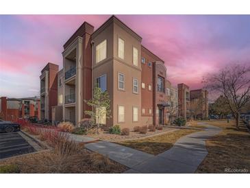 Inviting condo exterior with manicured landscaping, warm-toned stucco and brick accents, plus private balconies at 14321 E Tennessee Ave # 1-307, Aurora, CO 80012