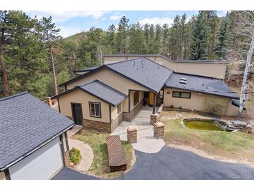 Charming single-story home featuring a beautiful yard with a pond and convenient circular driveway at 32173 Soda Creek Dr, Evergreen, CO 80439