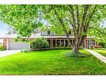 Charming brick home with a lush green lawn and mature trees at 3720 S Willow Cir, Denver, CO 80237