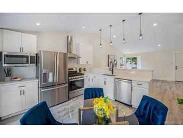 Bright kitchen with stainless appliances, modern white cabinetry, and stylish pendant lighting at 11510 Otis St, Westminster, CO 80020