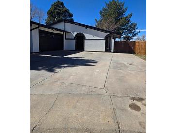 Charming single-story home with a well-maintained front yard and an attached two-car garage at 1051 Jasper St, Aurora, CO 80011