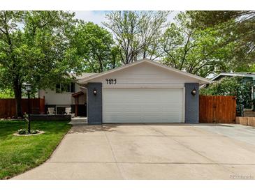 Charming home featuring an attached two-car garage, a driveway, and a well-maintained front yard with mature trees at 4643 S Vrain St, Denver, CO 80236