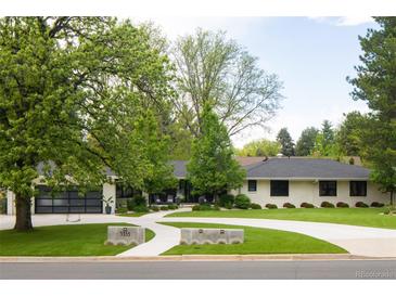 Charming ranch-style home with a landscaped front yard, modern garage door, and a winding concrete driveway at 3355 E Eastman Ave, Denver, CO 80210