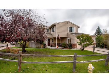 Charming two-story home featuring a well-maintained lawn and a welcoming front porch with stylish columns at 12780 Elm St, Thornton, CO 80241