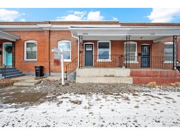 Charming brick home featuring a covered porch and well-maintained landscaping at 1853 W 41St Ave, Denver, CO 80211