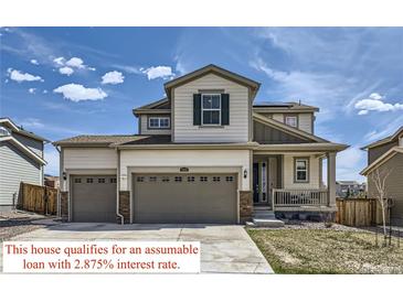 Charming two-story home featuring a two-car garage and inviting front porch under a bright blue sky at 9466 Quintero St, Commerce City, CO 80022
