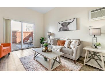 Inviting living room featuring modern decor, a cozy sofa, and a sliding door to the outdoor patio at 1315 Estes St # 13C, Denver, CO 80215