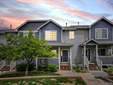 Charming townhome featuring a well-maintained lawn, colorful sky and inviting front entry at 19246 E Carolina Pl # 102, Aurora, CO 80017