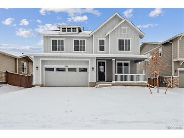 Two-story house with gray siding, white trim, and a snow-covered front yard at 3242 Boral Owl Dr, Brighton, CO 80601