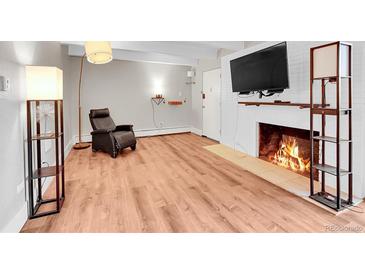 Spacious living room featuring laminate floors and a cozy fireplace at 655 N Pearl St # 108, Denver, CO 80203