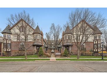 Charming Tudor-style townhomes feature brick and stucco exteriors, accented by mature trees and manicured landscaping at 76 S Garfield St, Denver, CO 80209