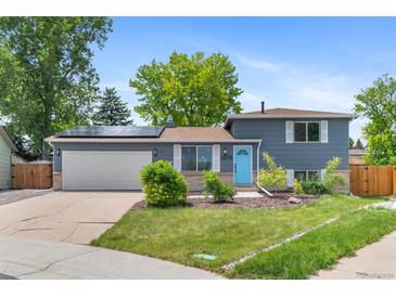 Charming gray two-story home featuring solar panels and a bright blue front door at 9275 W Euclid Ave, Littleton, CO 80123
