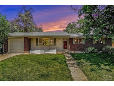 Charming brick home with white trim, a well-manicured lawn, and a cozy, inviting curb appeal at sunset at 8675 W 60Th Ave, Arvada, CO 80004