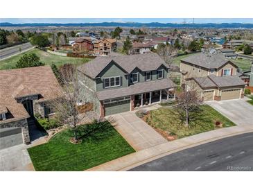 Charming two-story home with a well-maintained front lawn and a spacious driveway in a Gathering-friendly neighborhood at 22021 Pebble Brook Ln, Parker, CO 80138