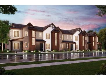 Modern townhome complex with diverse color schemes and covered entrances reflecting in the wet street at 6807 Huddersfield Ln, Castle Pines, CO 80108