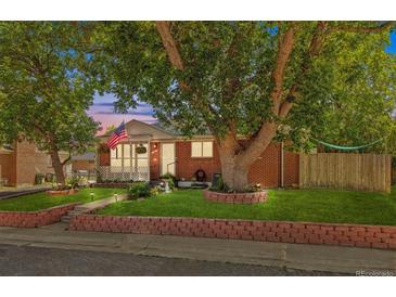 Charming brick home featuring a spacious front yard with mature trees and classic curb appeal at 1922 Graves Ct, Northglenn, CO 80233