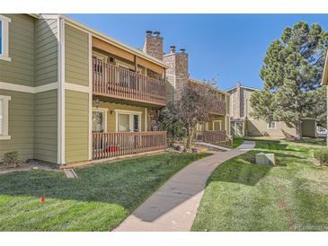 Exterior view of condo building showing walkway and green landscaping at 3452 S Eagle St # 201, Aurora, CO 80014