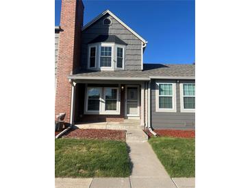 Charming two-story townhome with well-maintained front yard and gray and brick facade under a blue sky at 16901 E Chenango Ave # E, Aurora, CO 80015