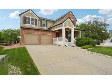 Charming two-story home featuring a brick facade, covered porch, and attached two-car garage at 641 Briar Haven Dr, Castle Pines, CO 80108