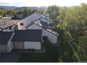 Beautiful exterior view of townhomes with well-maintained lawns and mature trees with mountain views in the background at 8394 S Everett Way # E, Littleton, CO 80128