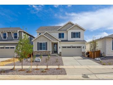 Charming two-story home with neutral siding, stone accents, well-manicured landscaping, and an attached two-car garage at 25234 E Warren Pl, Aurora, CO 80018