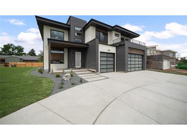 Stunning modern home showcasing a three-car garage, concrete driveway and minimalist landscaping at 5224 Lions Paw St, Castle Rock, CO 80104