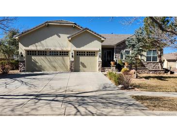 Charming single Gathering home featuring a three car garage, stone accents, and professionally landscaped front yard at 16699 Las Brisas Dr, Broomfield, CO 80023