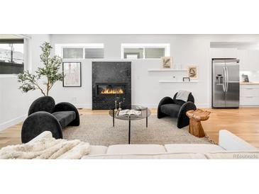 Cozy living room featuring a modern fireplace, stylish seating, and lots of natural light at 3658 Quivas St, Denver, CO 80211