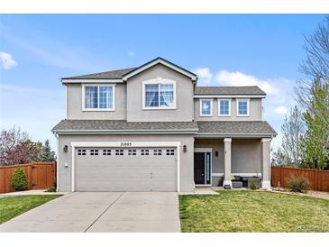 Charming two-story home boasts a manicured lawn, attached two-car garage and a welcoming covered porch at 21005 Glacier Park Cv, Parker, CO 80138