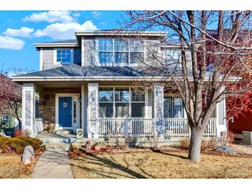 Charming two-story home featuring a welcoming front porch with stone accents and well-maintained landscaping at 16367 E Auburn Hills Dr, Parker, CO 80134