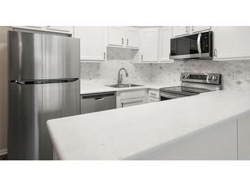 Modern kitchen with stainless steel appliances and white cabinets at 3663 S Sheridan Blvd # 2, Denver, CO 80235