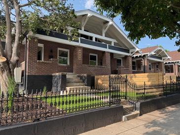 Charming brick home featuring a manicured lawn, decorative iron fence, and inviting entrance steps at 3922 W 29Th Ave, Denver, CO 80212