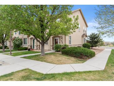 Inviting exterior view of a townhome featuring a well-maintained lawn and attractive stone accents at 12770 Jasmine Ct, Thornton, CO 80602
