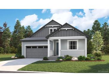 Charming two-story home featuring a well-manicured lawn, gray siding, covered entry and attached garage at 8294 Snake River St, Littleton, CO 80125