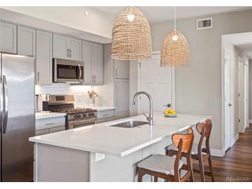 Modern kitchen with stainless steel appliances, white countertops, and pendant lighting at 210 S Cherrywood Dr # 303, Lafayette, CO 80026