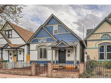 Charming blue and white two-story home with peaked roof and inviting front porch behind black iron fence at 160 W Bayaud Ave, Denver, CO 80223