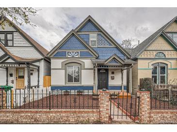 Charming blue and white home featuring a brick and iron fence, complemented by a well-maintained front yard at 160 W Bayaud Ave, Denver, CO 80223