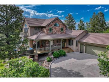 Beautiful home featuring stone accents, large covered porch, and attached two car garage at 5519 Ponderosa Dr, Parker, CO 80134