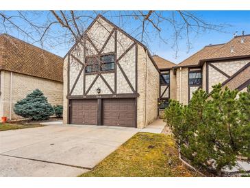Charming Tudor-style townhome featuring a two-car garage and brick and timber accents at 7250 Eastmoor Dr # 119, Denver, CO 80237