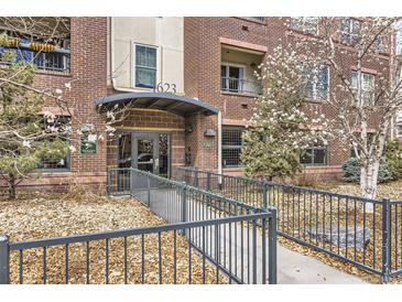Welcoming entrance of a brick building featuring well-kept landscaping and accessible ramp at 1623 Saint Paul St # 306, Denver, CO 80206