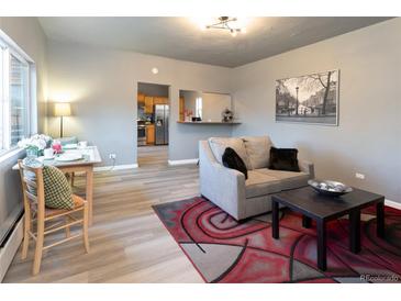 Cozy living room with hardwood floors, and a view of the kitchen through the open doorway at 4595 S Lincoln St, Englewood, CO 80113