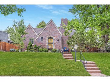 Charming brick home featuring a manicured lawn, brick steps, mature trees, and stylish curb appeal at 926 S Fillmore Way, Denver, CO 80209