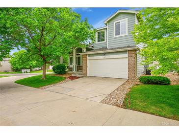 Charming two-story home with a brick-accented garage, well-manicured lawn, and mature trees at 10571 Garfield St, Thornton, CO 80233