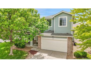 Charming two-story home featuring a well-maintained lawn and attached garage at 10571 Garfield St, Thornton, CO 80233