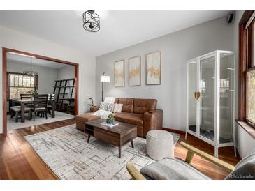 Comfortable living room featuring hardwood floors, a modern light fixture, and stylish furnishings at 2023 E 20Th Ave, Denver, CO 80205