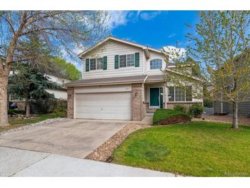 Charming two-story home featuring a two car garage, mature landscaping, and a beautiful lawn at 10517 Madison St, Thornton, CO 80233