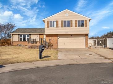 Charming split-level home featuring tan siding, brick accents, and a two-car garage at 11535 Albion Ct, Thornton, CO 80233