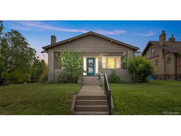 Charming craftsman-style bungalow with a welcoming front porch and well-maintained lawn at dusk at 2703 N Milwaukee St, Denver, CO 80205