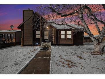 Charming ranch home with wood siding and snow-covered yard at 245 Cedar St, Hudson, CO 80642